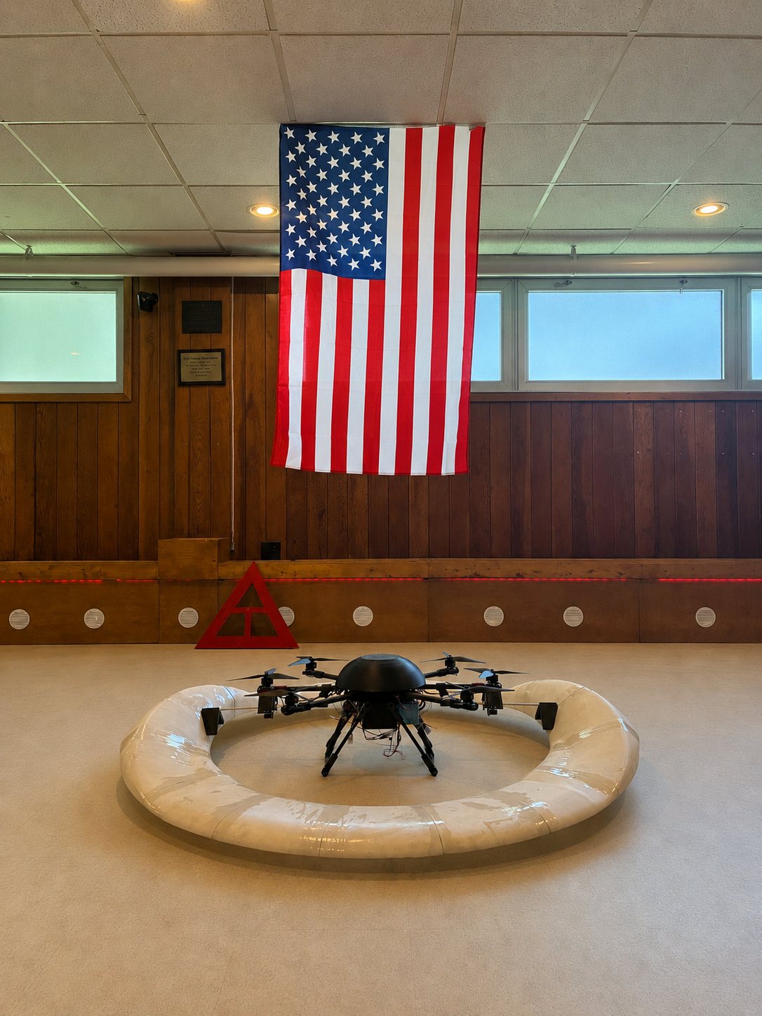 The Astra V1 prototype resting inside its white airfoil ring, beneath an American flag