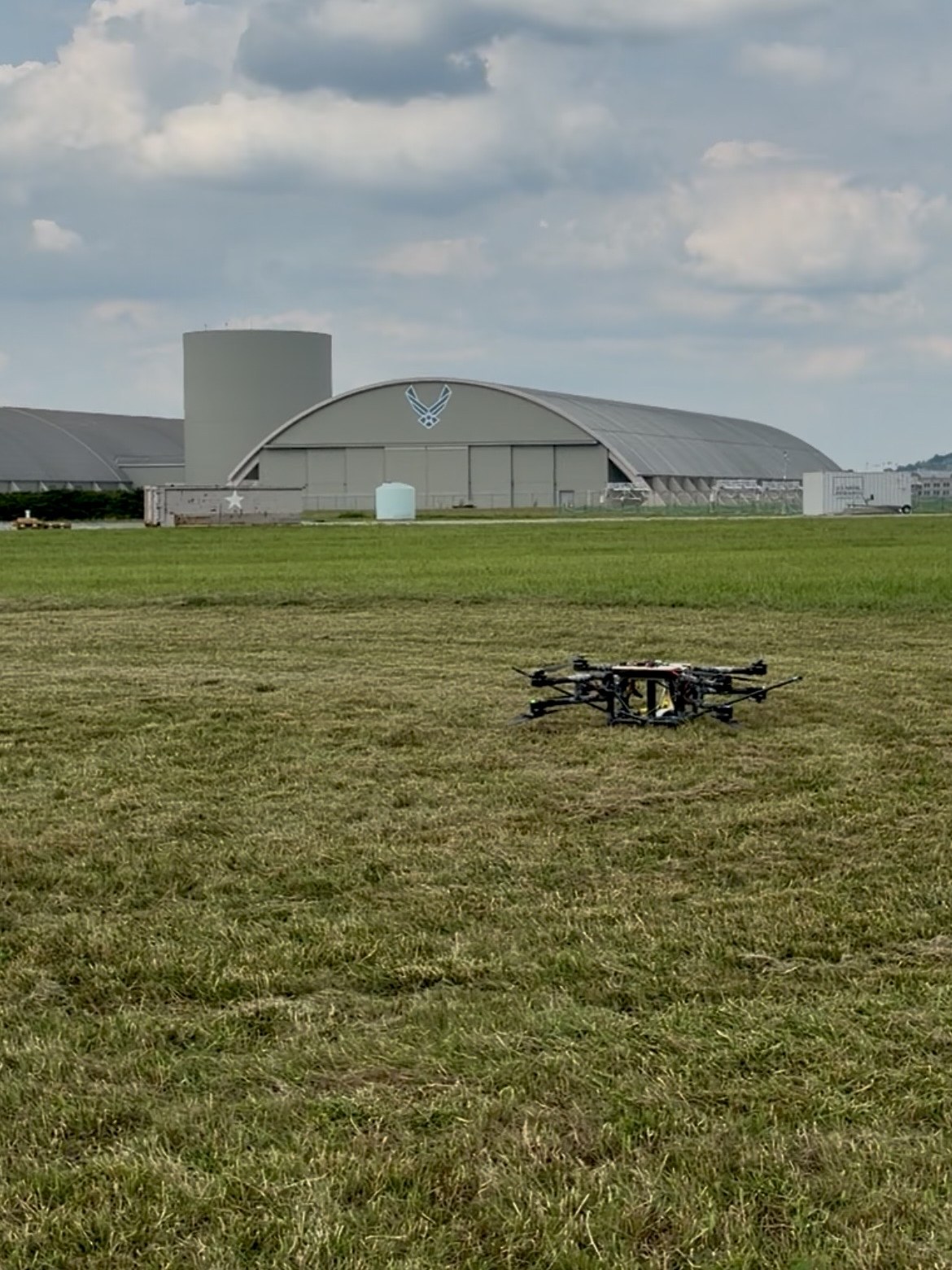 Astra V2 sitting on the grass at an Air Force airfield, a hangar behind it